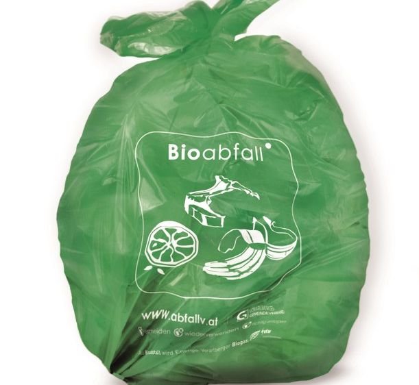 Ein grüner biologisch abbaubarer Müllsack mit der Aufschrift Bioabfall, konzipiert für organische Abfälle, mit verschiedenen Symbolen wie einem Obststück, einem Blatt und einem Recycling-Symbol darauf.