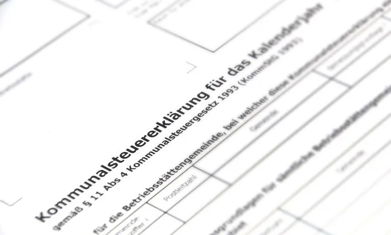 Ein Nahaufnahme eines Dokuments mit Text auf Deutsch, einschließlich 'Kommunalsteuererklärung', '1993' und 'Postleitzahl', scheint ein Formular für die kommunale Steuererklärung zu sein.