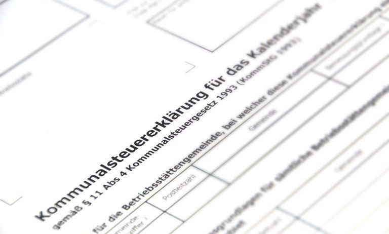 Ein Nahaufnahme eines Dokuments mit Text auf Deutsch, einschließlich 'Kommunalsteuererklärung', '1993' und 'Postleitzahl', scheint ein Formular für die kommunale Steuererklärung zu sein.