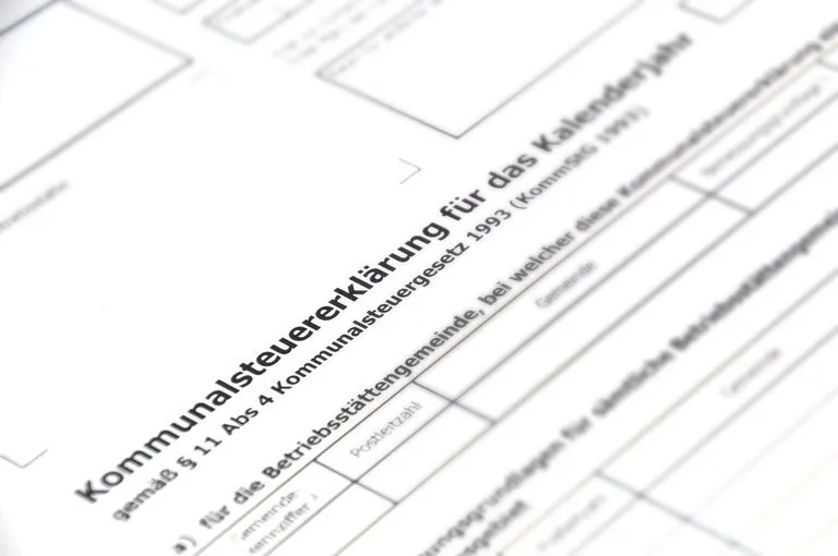Ein Nahaufnahme eines Dokuments mit Text auf Deutsch, einschließlich 'Kommunalsteuererklärung', '1993' und 'Postleitzahl', scheint ein Formular für die kommunale Steuererklärung zu sein.