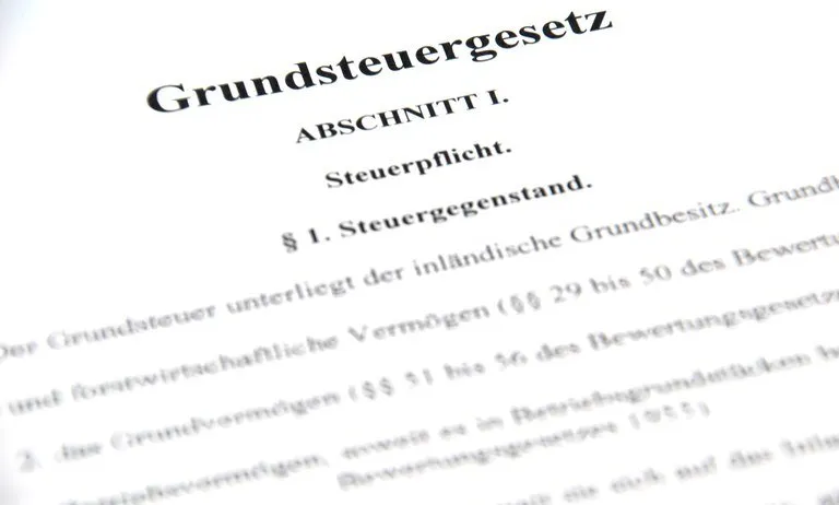 Nahaufnahme einer Seite mit deutschem Text, der oben 'Grundsteuergesetz' und darunter eine Abschnittsnummer und 'Steuerpflicht' aufweist. Darunter sind verschiedene Zahlen und Buchstaben, die Steuerdetails angeben.