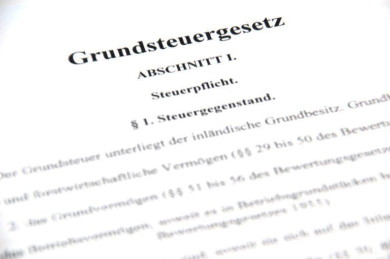 Nahaufnahme einer Seite mit deutschem Text, der oben 'Grundsteuergesetz' und darunter eine Abschnittsnummer und 'Steuerpflicht' aufweist. Darunter sind verschiedene Zahlen und Buchstaben, die Steuerdetails angeben.