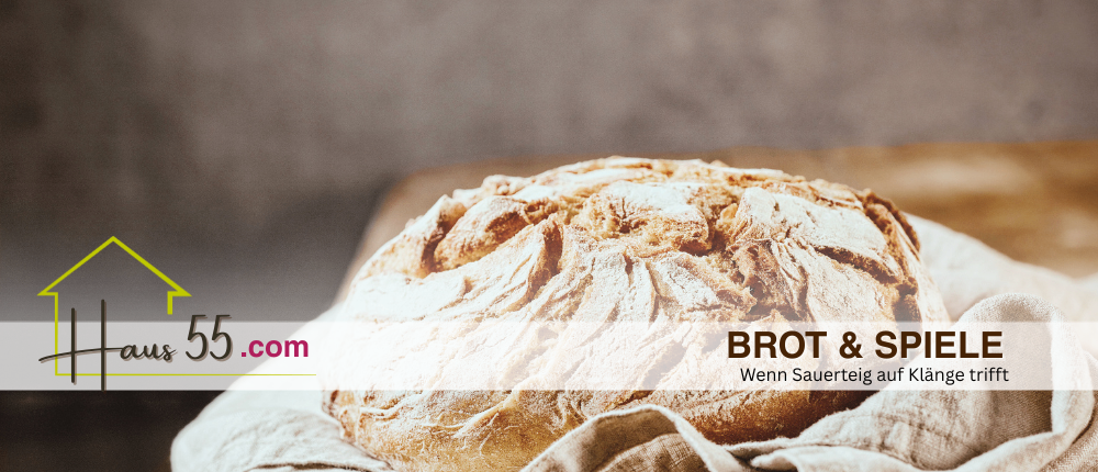 A golden loaf of bread rests on a white cloth. A blurry background features the text 'BROT & SPIEL' and a website address.