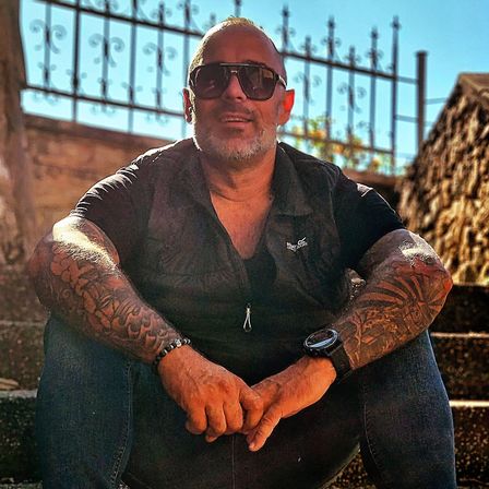 Bild enthält, Sunglasses, Person, Skin, Tattoo, Pants, Adult, Male, Man, Sitting, Sleeve