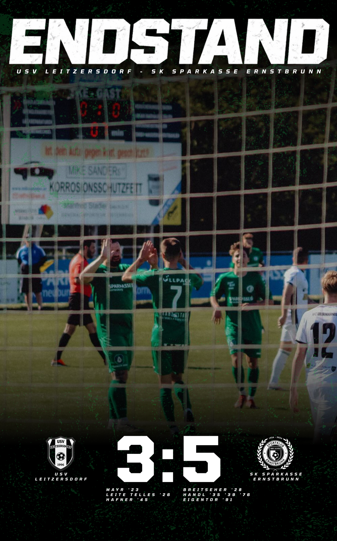 Fußballspieler in grünen Trikots feiern ein Tor auf einem Feld. Das Netz hinter ihnen zeigt die Punkte 0:0. Ein Werbebanner und ein Baum sind im Hintergrund zu sehen.