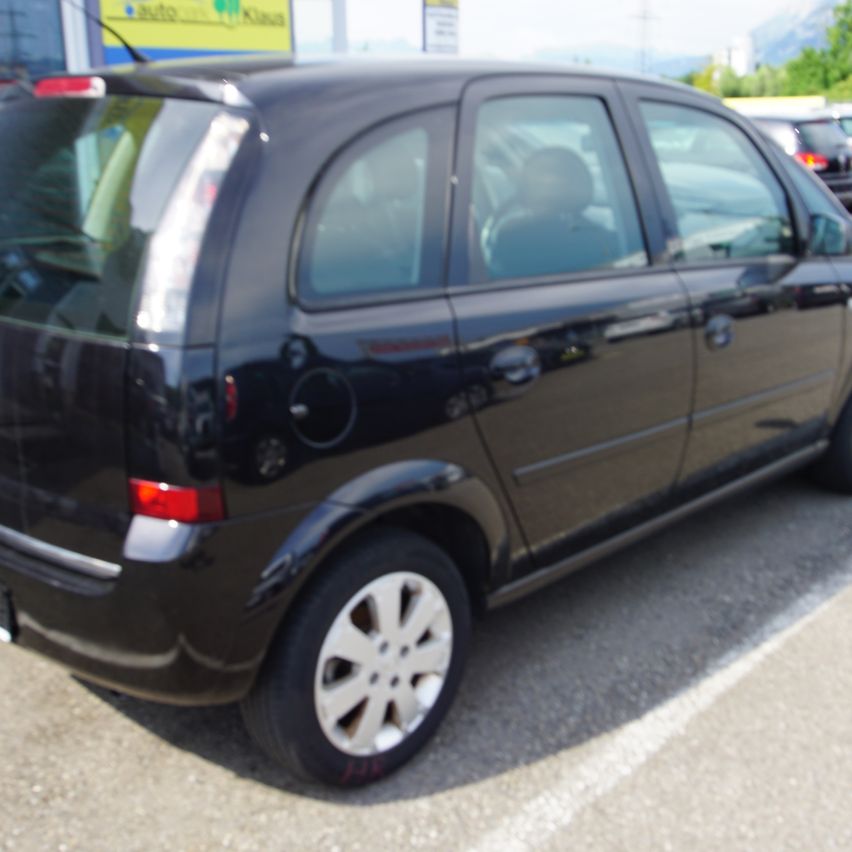Ein schwarzer Kompaktwagen steht auf einem Parkplatz. Das Heck des Autos ist sichtbar mit einem roten Rücklicht.