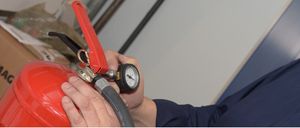 Nahaufnahme eines blauen Hemdes mit Kragen. Der Hintergrund ist eine weiße Wand mit blauem Rand.