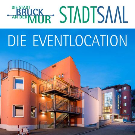 Ein modernes Gebäude mit einer Wendeltreppe, Glasfenstern und einem Schild mit der Aufschrift 'Die Eventlocation'. Es wird vom Abendsonnenschein beleuchtet, mit einem klaren blauen Himmel im Hintergrund.