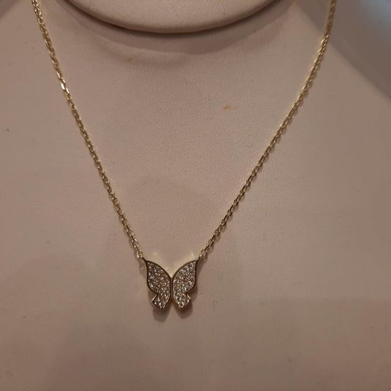Eine goldene Kettenkette mit einem Schmetterlingsanhänger, der Anhänger ist mit kleinen Diamanten bedeckt.