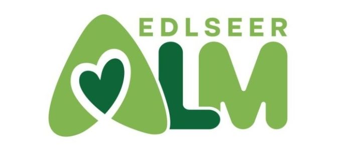 Das Logo für Edlseeer LM zeigt ein grünes Herzsymbol, das in die Buchstaben LM integriert ist, vor weißem Hintergrund.