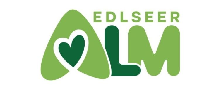 Das Logo für Edlseer, bestehend aus einem grünen Herz und den Buchstaben LM.