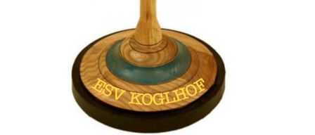 A wooden spinning top with a handle, featuring the words ESV Koglhof in yellow on a brown and blue surface.