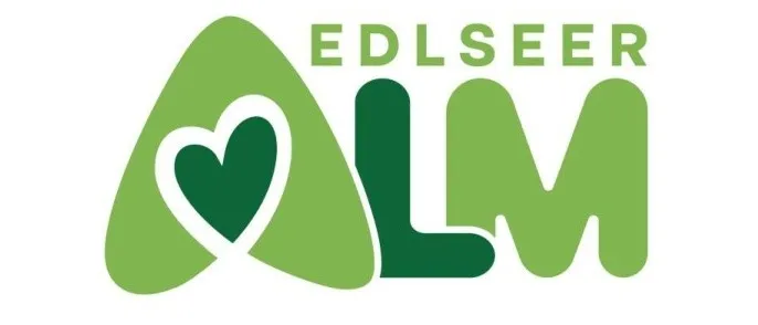 Das Logo der Edlseer Alm zeigt ein grünes Herz in einem stilisierten Buchstaben 'A' mit 'LM' darunter, vor einem weißen Hintergrund.