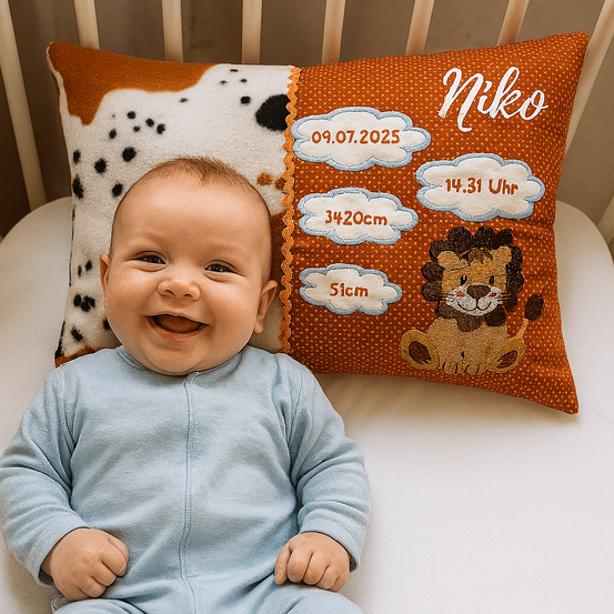 Ein lächelndes Baby liegt in einem Kinderbett mit einem Kissen, das 'Niko' zeigt, mit Details wie Geburtsdatum, Gewicht und Länge.