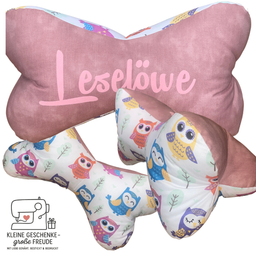 Rosa Nackenkissen mit Eulenmuster, in Knochenform mit dem Namen 'Leselove'. Es ist für Komfort ausgelegt, mit mehreren Eulen in verschiedenen Farben. Ein Geschenkidee mit einem Nählogo und dem Slogan 'kleine Geschenke - große Freude'.