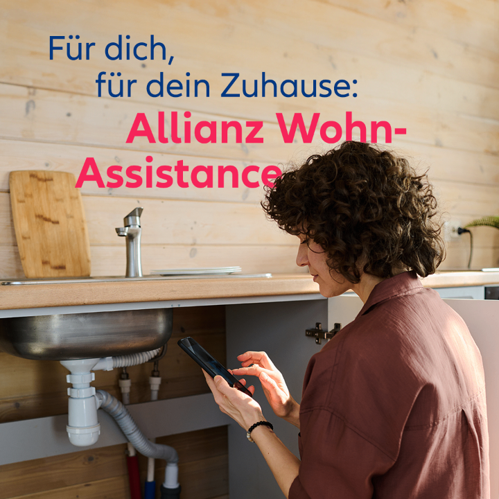 A woman is in a kitchen, checking her smartphone with a faucet, sink, and pipe visible in the background. Above her is a wooden wall with text reading 'Allianz Wohn-Assistance'.