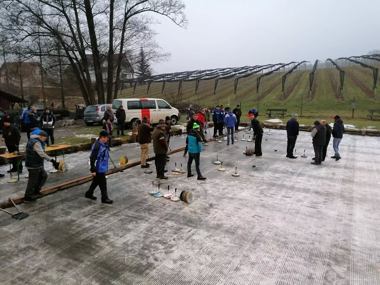 Bild enthält, Person, Clothing, Glove, Car, Bench, Outdoors, Hat, Wheel, Shoe, Worker