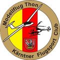 Das Emblem des Karntner Flugsport Clubs zeigt ein kreisförmiges Abzeichen mit einem stilisierten Flugzeug, Hubschrauber und einem Wappen in der Mitte. Der Hintergrund ist in rote, gelbe und weiße Abschnitte unterteilt. Die Worte 'Modelflug Thon' sind in Weiß oben geschrieben.