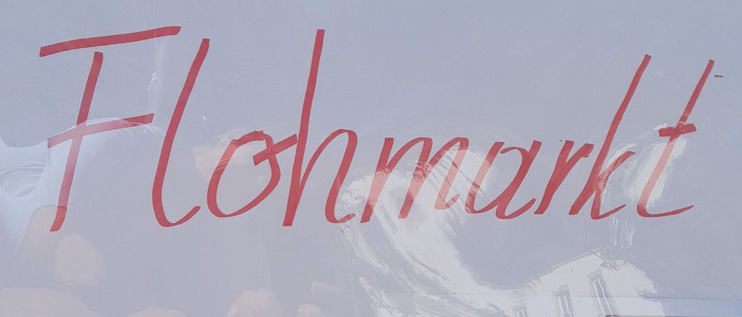 Ein Plakat bewirbt die Flohmarkt-Veranstaltung. Sie wird von Caritas & Du organisiert und findet von 9:00 bis 11:00 im Caritas-Zentrum statt. Die Veranstaltung beinhaltet die Möglichkeit, Gegenstände zu spenden.