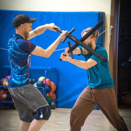 Bild enthält, Sword, Weapon, Baseball Cap, Cap, Clothing, Hat, Person, Swordfight