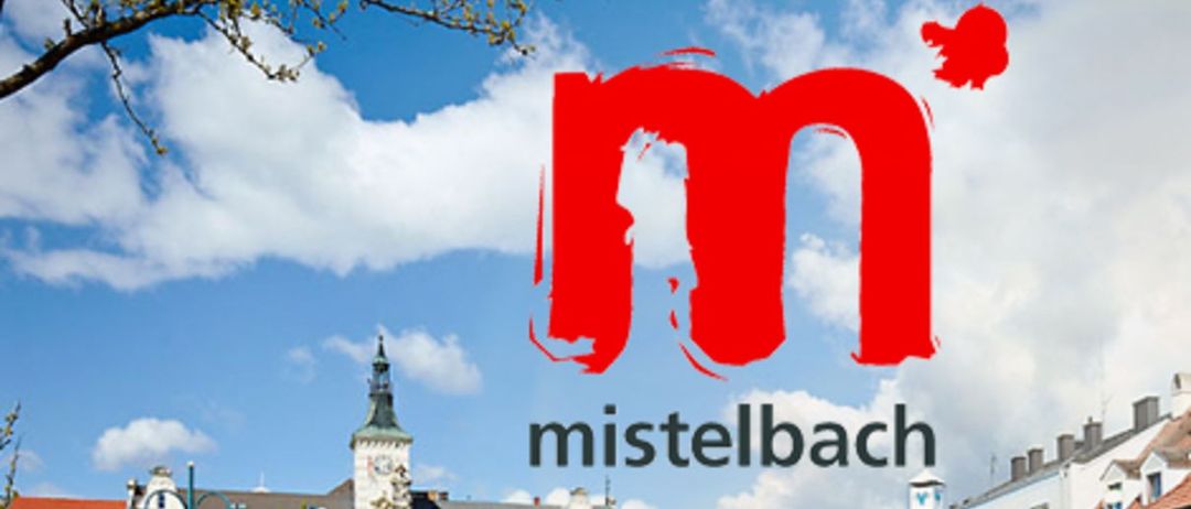 Mistelbach Stadtlogo mit einer Brücke und einem großen Gebäude im Hintergrund, mit bunten Blumen im Vordergrund.