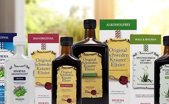 Eine Sammlung von Flaschen mit Kräuterelixieren, einschließlich Original Schweden Kräuter Elixir, Original Kräuter Elixir und Riviera Melissengeist, vor einem verschwommenen Hintergrund ausgestellt.