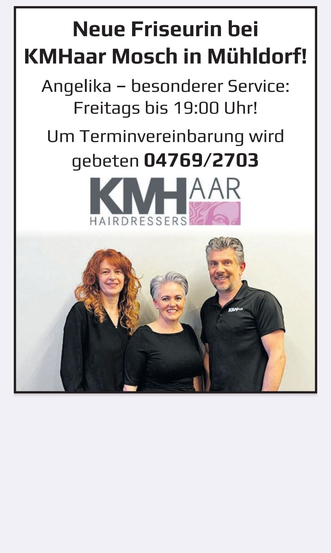 Three people are posing for a photo in front of a white wall. The man is wearing a black polo shirt. The two women are wearing black shirts. The poster behind them has a logo and a phone number.