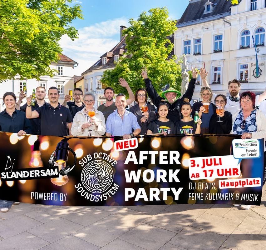 A group of people holding drinks, standing behind a banner that says 'After Work Party'. They are smiling and posing for a photo in front of a building.