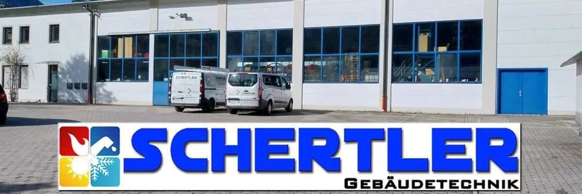 Zwei weiße Lieferwagen sind vor einem Gebäude mit großen Fenstern und dem prominenten Wort 'SCHERTLE' geparkt. Das Gebäude hat ein modernes, industrielles Aussehen.