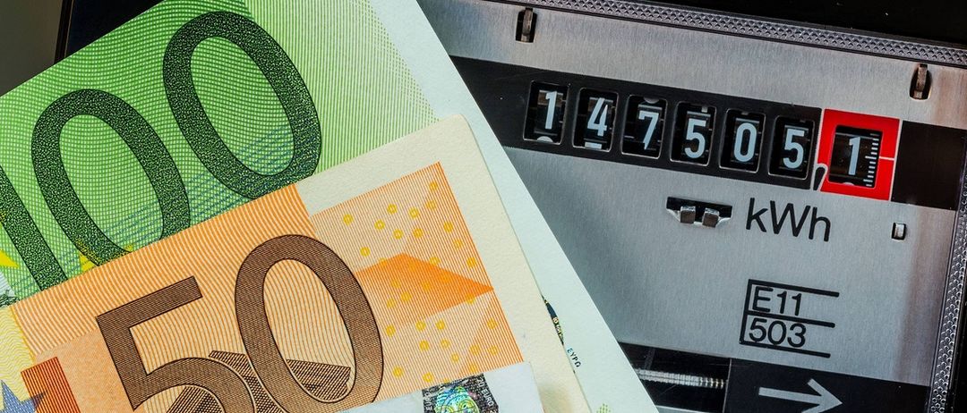 Nahaufnahme einer Euro-Banknote mit einem digitalen Stromzähler, der 1475,05 Kilowatt anzeigt.