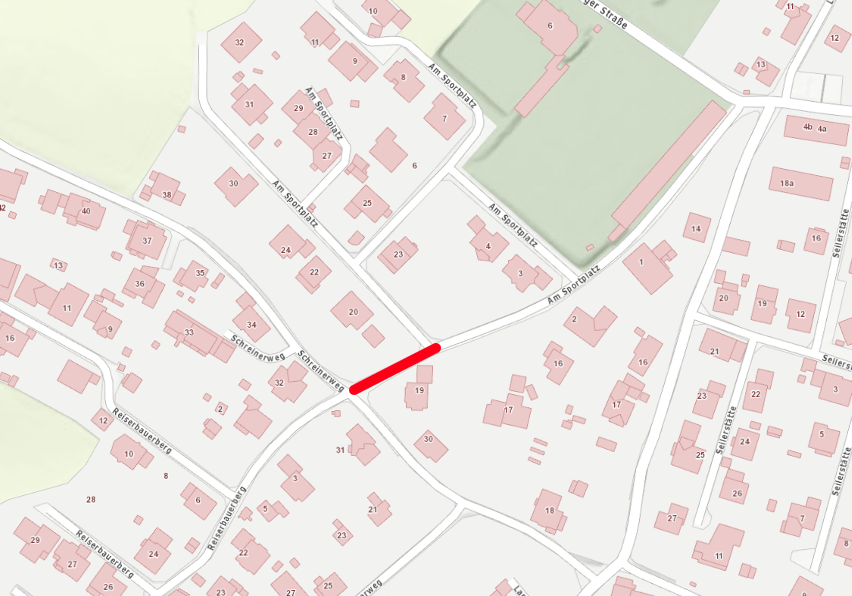 Map showing a neighborhood with numbered buildings and streets. A red line indicates a route through the area.