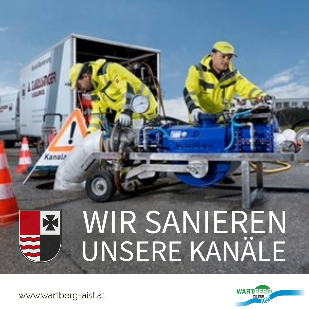 Two workers in yellow safety suits are working on a blue machine with a white hose connected to it. They are standing in front of a white truck with a logo and the text 'Wir sanieren unsere Kanale'. There are orange traffic cones and a logo on the left side of the image.