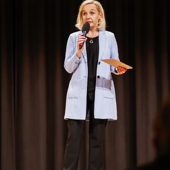 Bild enthält, Microphone, Crowd, Person, Coat, People, Audience, Solo Performance, Speech, Face, Shoe