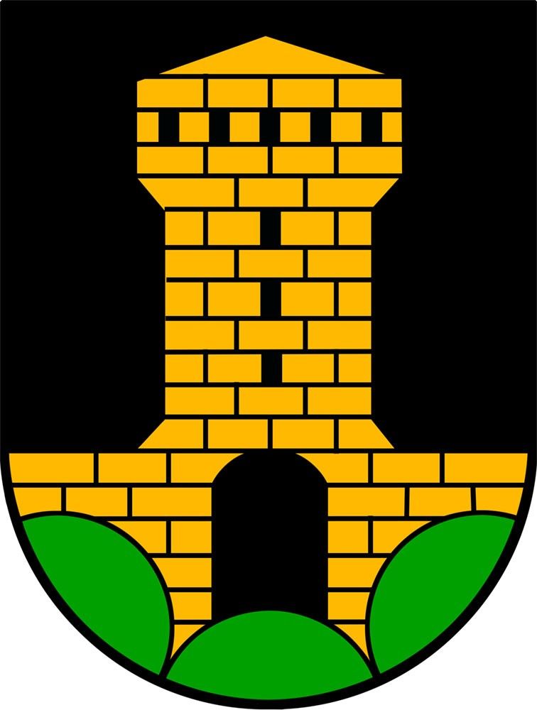 Ein schwarzer Schild mit einem gelben Backsteinturm, der drei Fenster, einen gewölbten Eingang und zwei grüne Blätter am Boden aufweist.