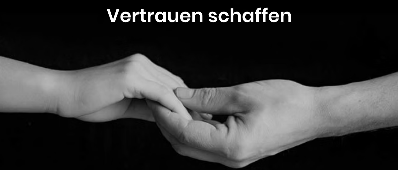 Ein Schwarz-Weiß-Bild zeigt zwei Hände, die ineinander verschlungen sind. Die Bildunterschrift lautet 'Vertrauen schaffen'.