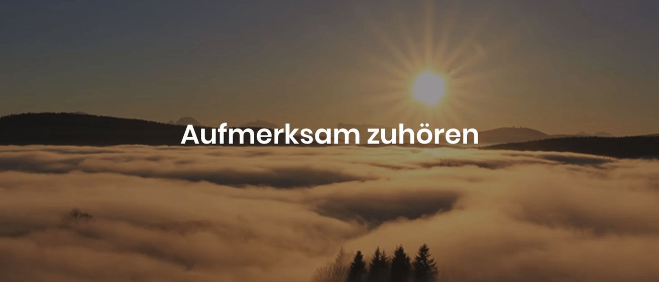 The sun shines brightly over a sea of clouds with mountains in the distance. The text 'Aufmerksam zuhören' is displayed.