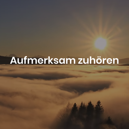 Eine strahlende Sonne erhebt sich über eine Wolkenmeer, das eine warme Ausleuchtung auf die Landschaft wirft. Im Vordergrund stehen Baumsilhouetten, die in den Nebel eingebettet sind. Die Worte 'Aufmerksam zuhören' erscheinen in weiß oben.