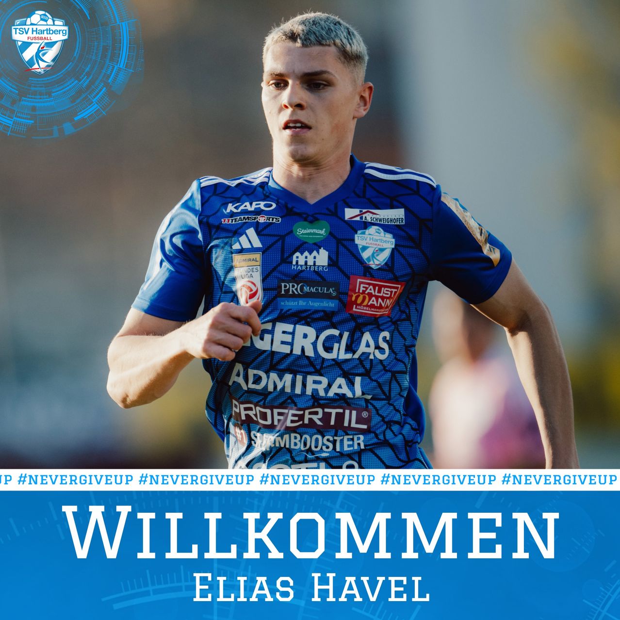 Ein Mann in einem blauen Trikot mit 'Willkommen Elias Havel' darunter, läuft bei einer Sportveranstaltung. Das Trikot hat mehrere Logos und Texte. Dahinter ist ein verschwommener Hintergrund.