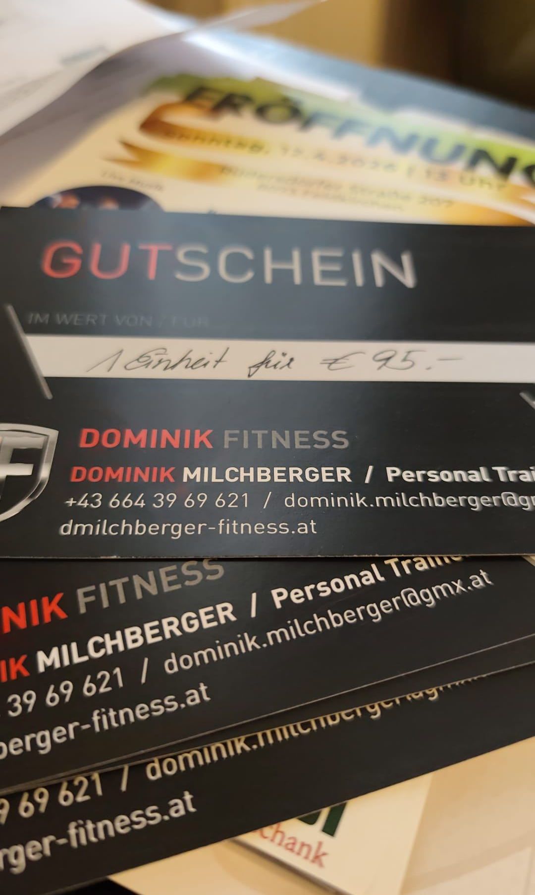 Gestapelte Visitenkarten für Dominik Fitness. Die oberste Karte zeigt Gutschein, Preis 95 Euro und den Firmennamen Dominik Milchberger. Die untere Karte listet Telefonnummer, E-Mail und Website auf.