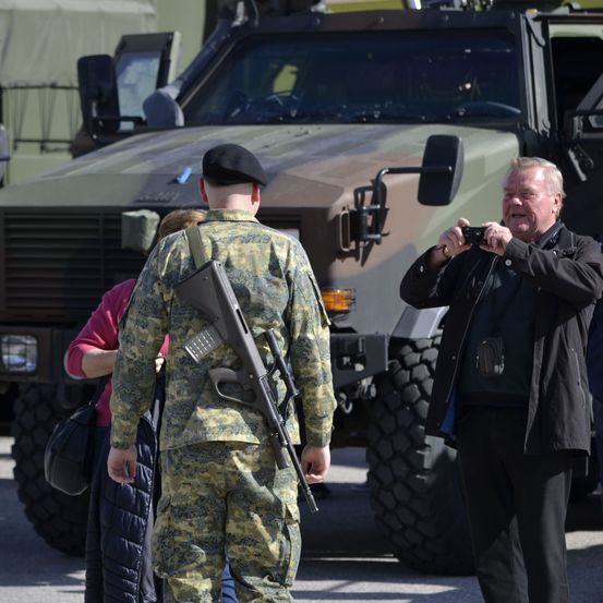 Bild enthält, Hat, Shoe, Handbag, Adult, Male, Man, Person, Gun, Camera, Glasses