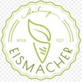 Ein grünes kreisförmiges Emblem mit den Worten "FISMMACHER" und einem Blattdesign. Es enthält einen Kegel mit Streifen und den Text "seit 1927". Der Rand hat ein gepunktetes Design.