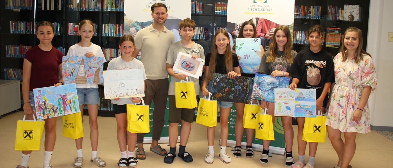 Eine Gruppe junger Kinder und ein erwachsener Mann posieren für ein Foto in einer Bibliothek. Sie halten gelbe Taschen und Zeichnungen. Der Hintergrund ist ein Banner mit einem Logo.