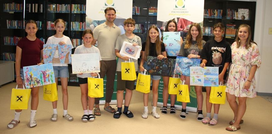 Eine Gruppe von Kindern und einem Mann steht in einer Bibliothek, hält gelbe Taschen und Zeichnungen. Ein Banner mit dem Text 'Mittelschule Pischelsdorf' ist hinter ihnen zu sehen.