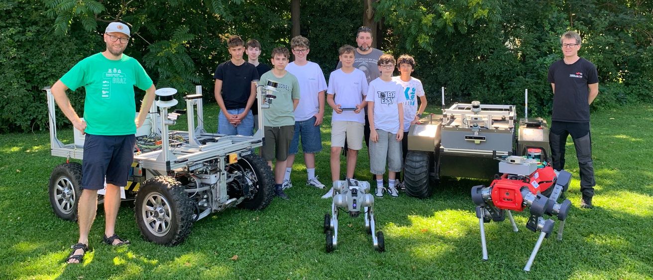 Roboter und junge Leute mit einem Forscherteam im Freien in der Steiermark