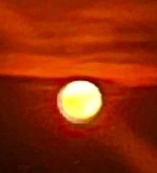 Ein verschwommenes Bild zeigt ein gelbes Licht vor einem rötlichen Hintergrund, möglicherweise von einem Sonnenaufgang oder Sonnenuntergang.