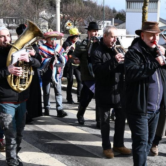 Eine Gruppe von Musikern, die Hüte und Stiefel tragen, spielt Instrumente wie Trompeten und Tubas auf der Straße.