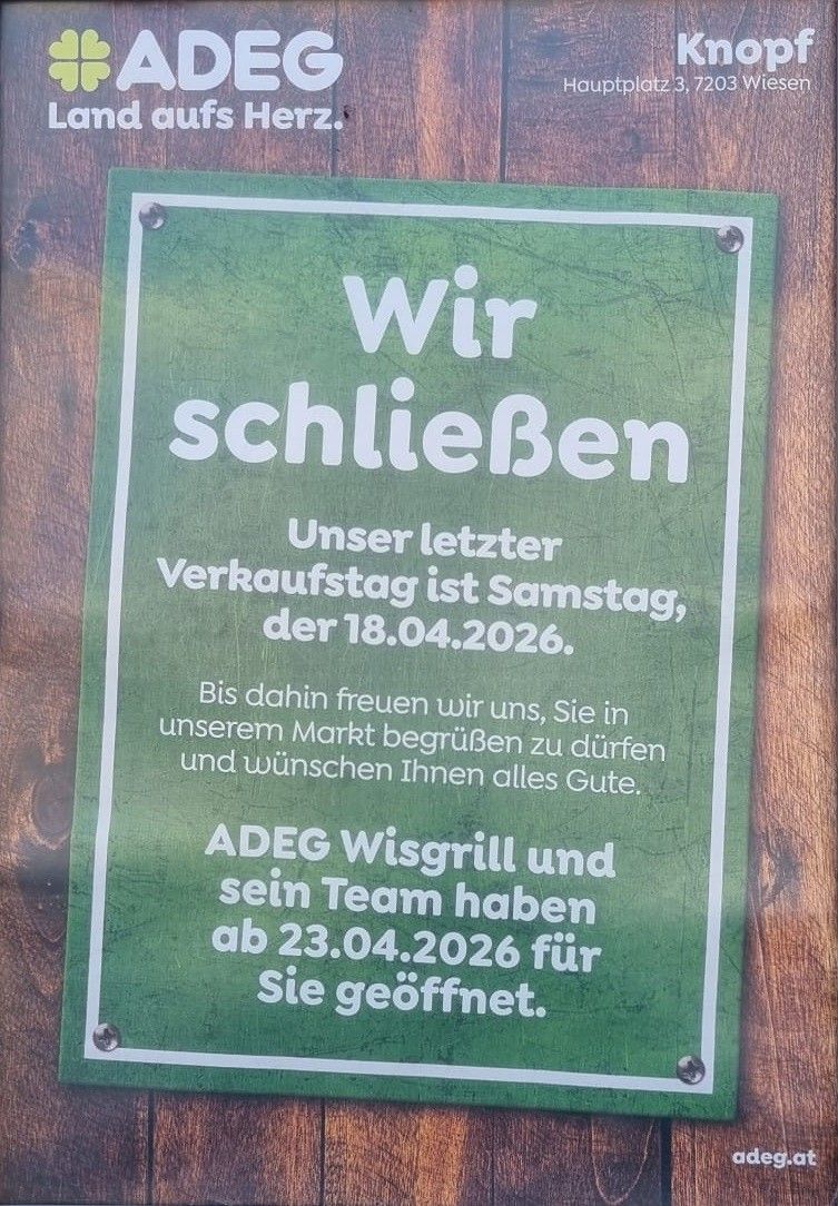 Ein Schild auf einer Holzoberfläche kündigt die Schließung eines Marktes am 18.04.2026 an. Es lädt bis dahin Besucher ein und erwähnt eine Neueröffnung durch ADEG Wisgrill und Team am 23.04.2026.