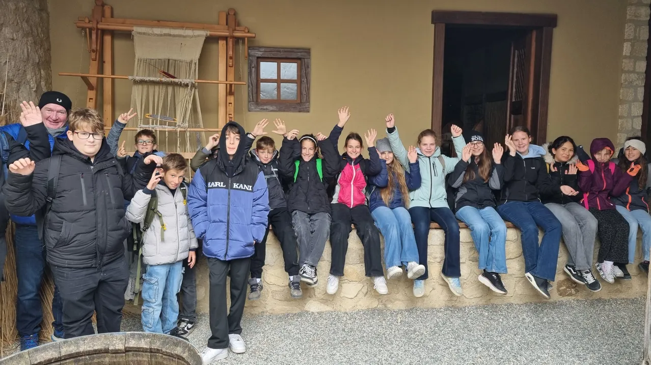 Eine Gruppe von Kindern und Erwachsenen posiert für ein Foto vor einem Gebäude.