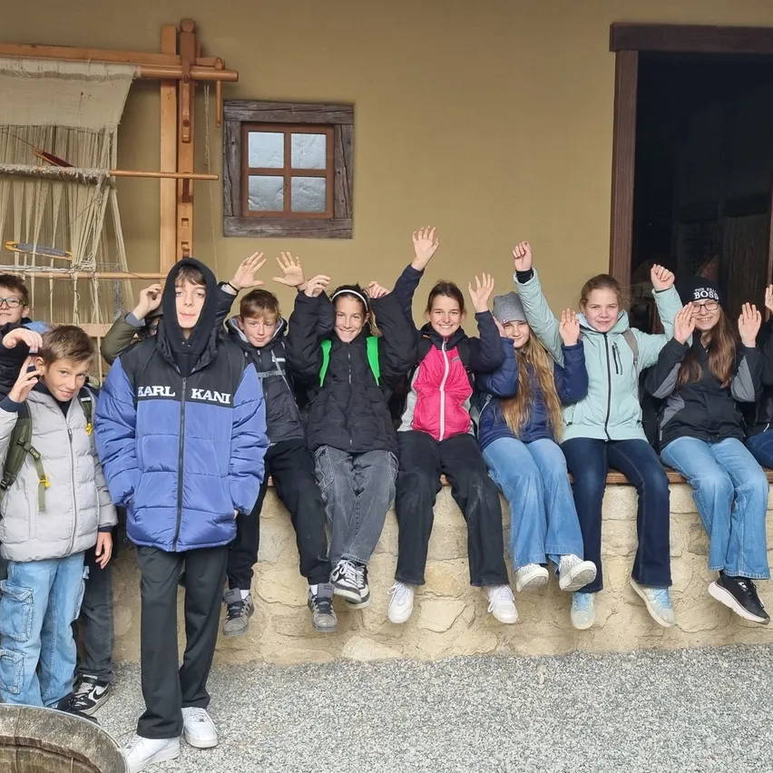Eine Gruppe von Kindern und Erwachsenen posiert für ein Foto vor einem Gebäude.
