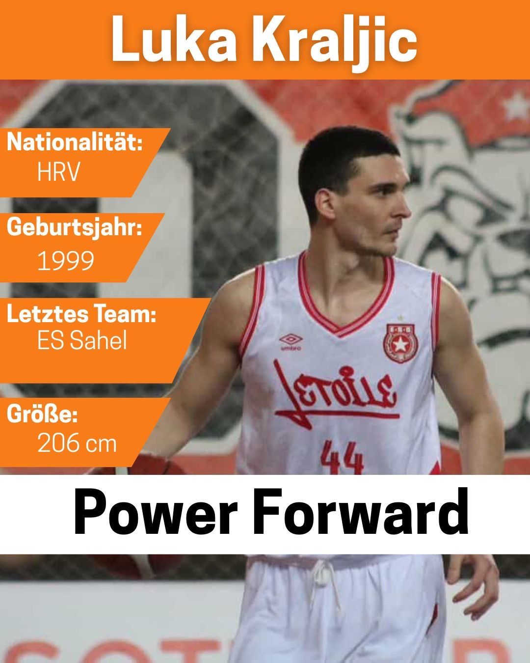 Ein männlicher Basketballspieler steht mit den Händen hinter dem Rücken. Er trägt ein weißes Trikot mit rotem Rand und der Nummer 44. Das Trikot hat das Wort 'Vetola' in Rot geschrieben. Der Hintergrund ist verschwommen mit Graffiti.